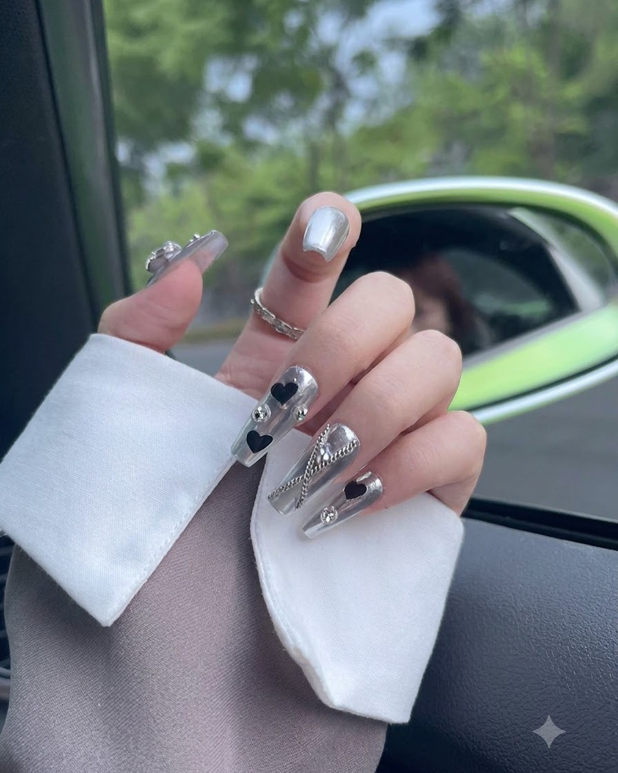 Nahaufnahme eines Daumennagels mit Chrom-Finish und einem funkelnden Kristall-Element.