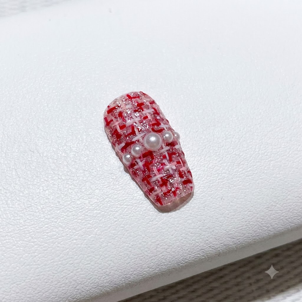 Ein feiner Pinsel füllt eine Seite eines V-förmigen French-Maniküre-Tips mit leuchtend rotem Gel-Lack aus.