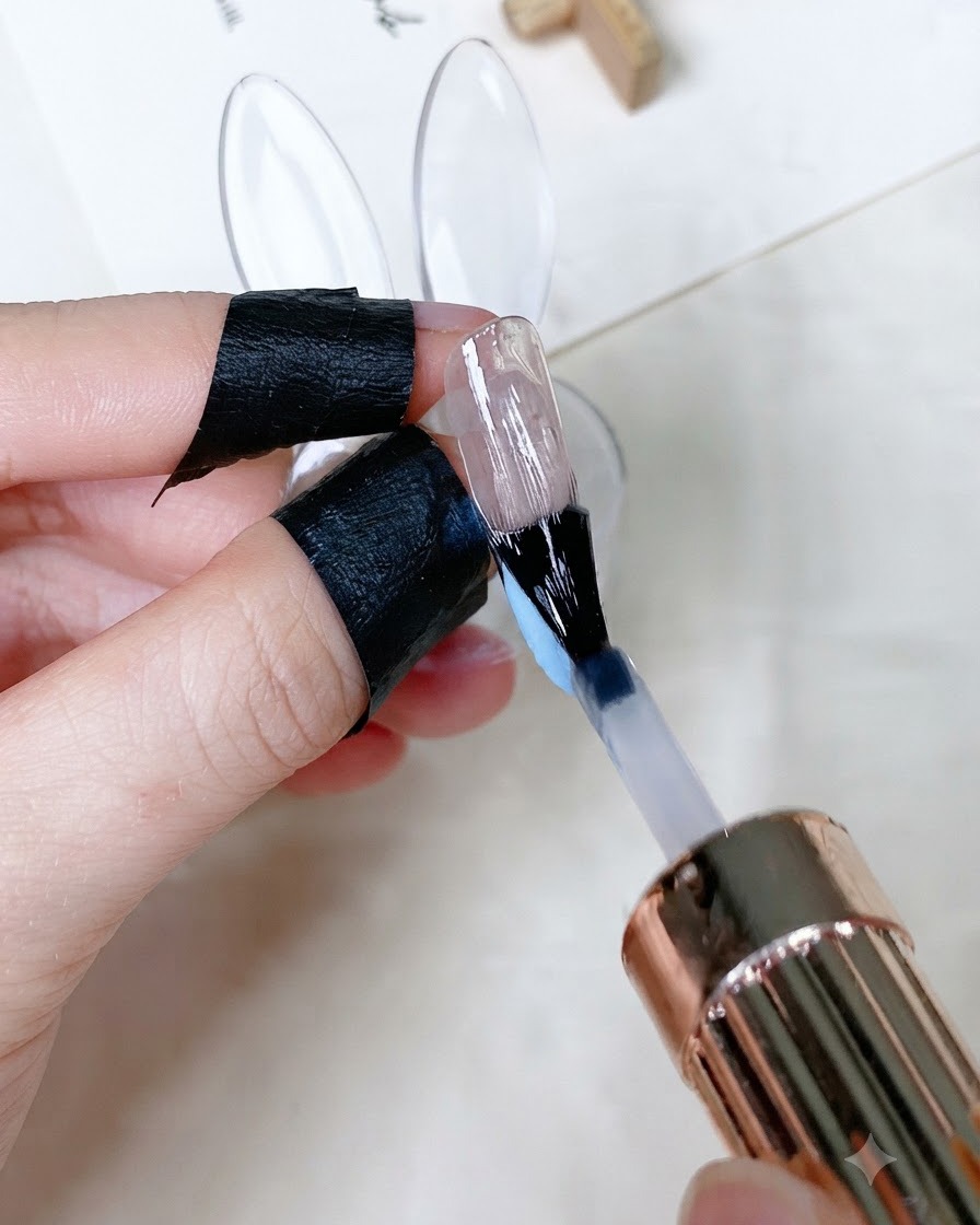 Ein Pinsel trägt einen klaren, glänzenden Top Coat auf einen lackierten Fingernagel auf.