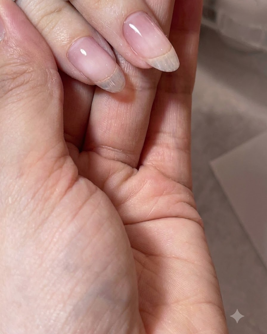 Eine Hand zeigt einen fertigen, perfekt strukturierten transparenten Gelnagel mit einem glatten Apex.