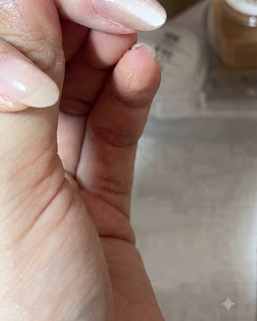 Nahaufnahme einer Hand, die einen Magnetstab diagonal über einen glänzenden, nacktfarbenen Gel-Nagel hält, um die Lichtsspiegelung zu formen.