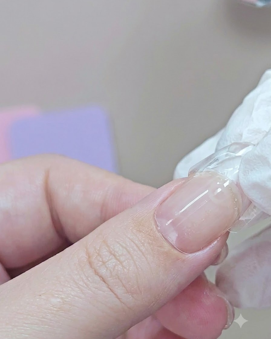 Ein Fingernagel mit angebrachter Dual Form wird unter einer blauen UV-Handlampe ausgehärtet.