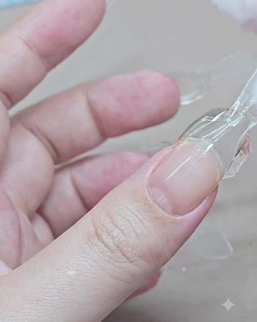 Eine Hand drückt und hebt eine klare Plastik-Dual-Form von einer ausgehärteten Gel-Verlängerung am Zeigefinger ab.