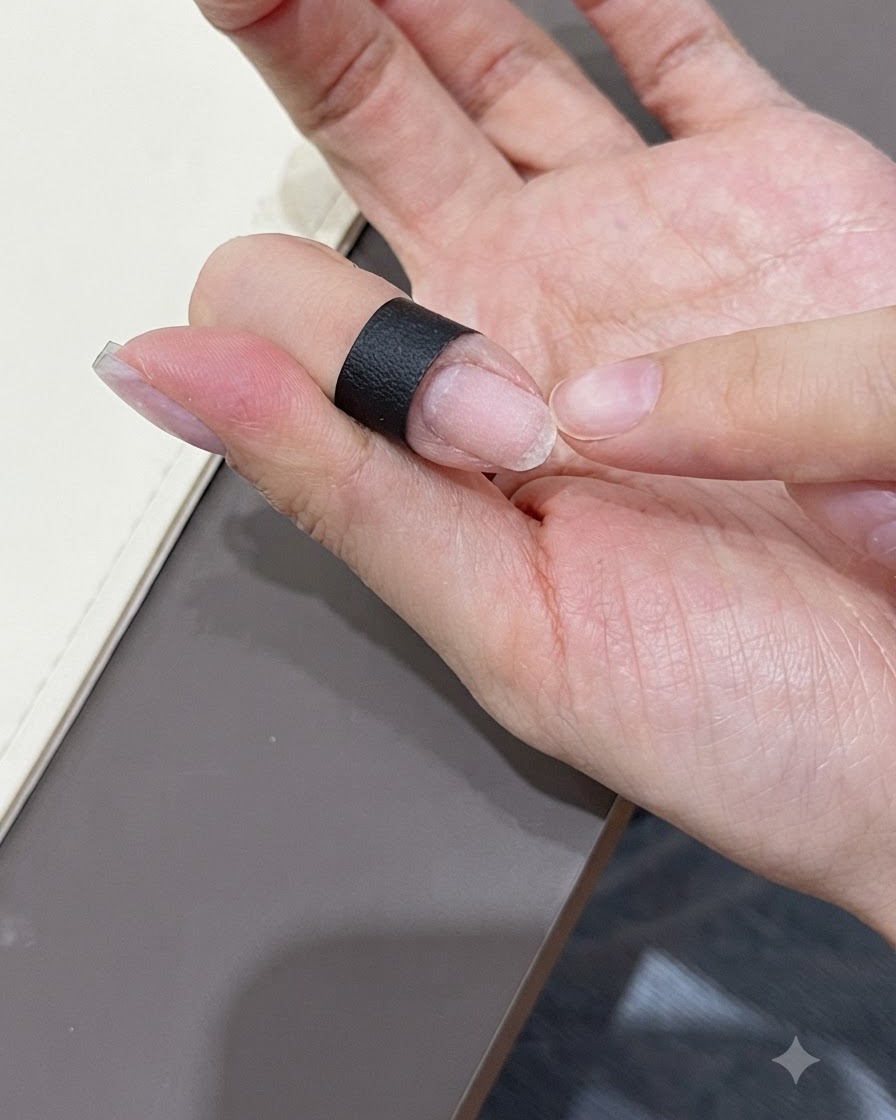 Nahaufnahme einer Hand, die eine klare, lange Nagelverlängerungsspitze nahe einem vorbereiteten Naturnagel hält.