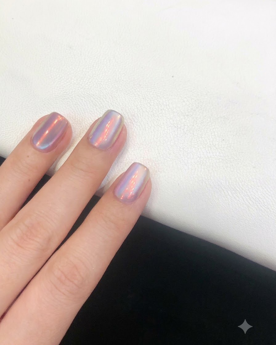 Ein Top-Coat-Pinsel gleitet glatt über den fertigen Nagel mit Aurora-Effekt, um das Design zu versiegeln.