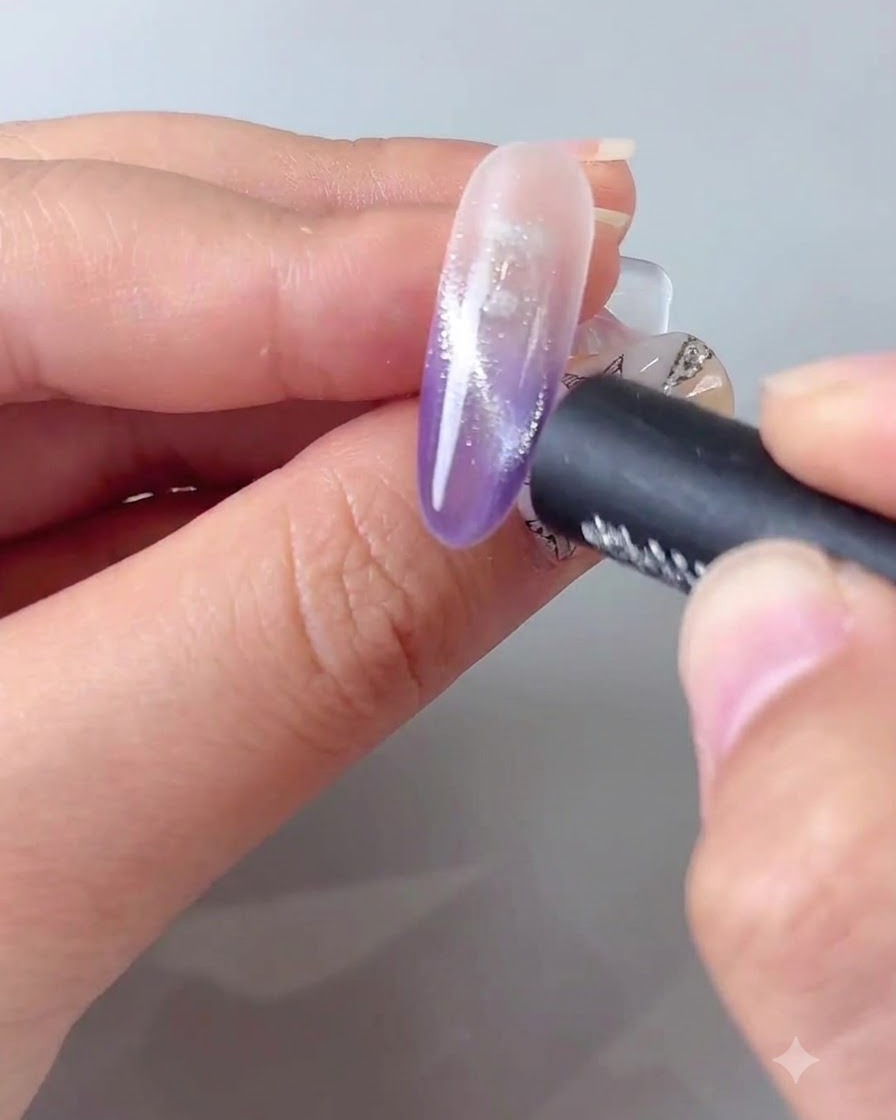 Ein Magnetstab, der nahe an einen lila Cat-Eye-Gel-Nagel gehalten wird, um den Schimmer zu konzentrieren.