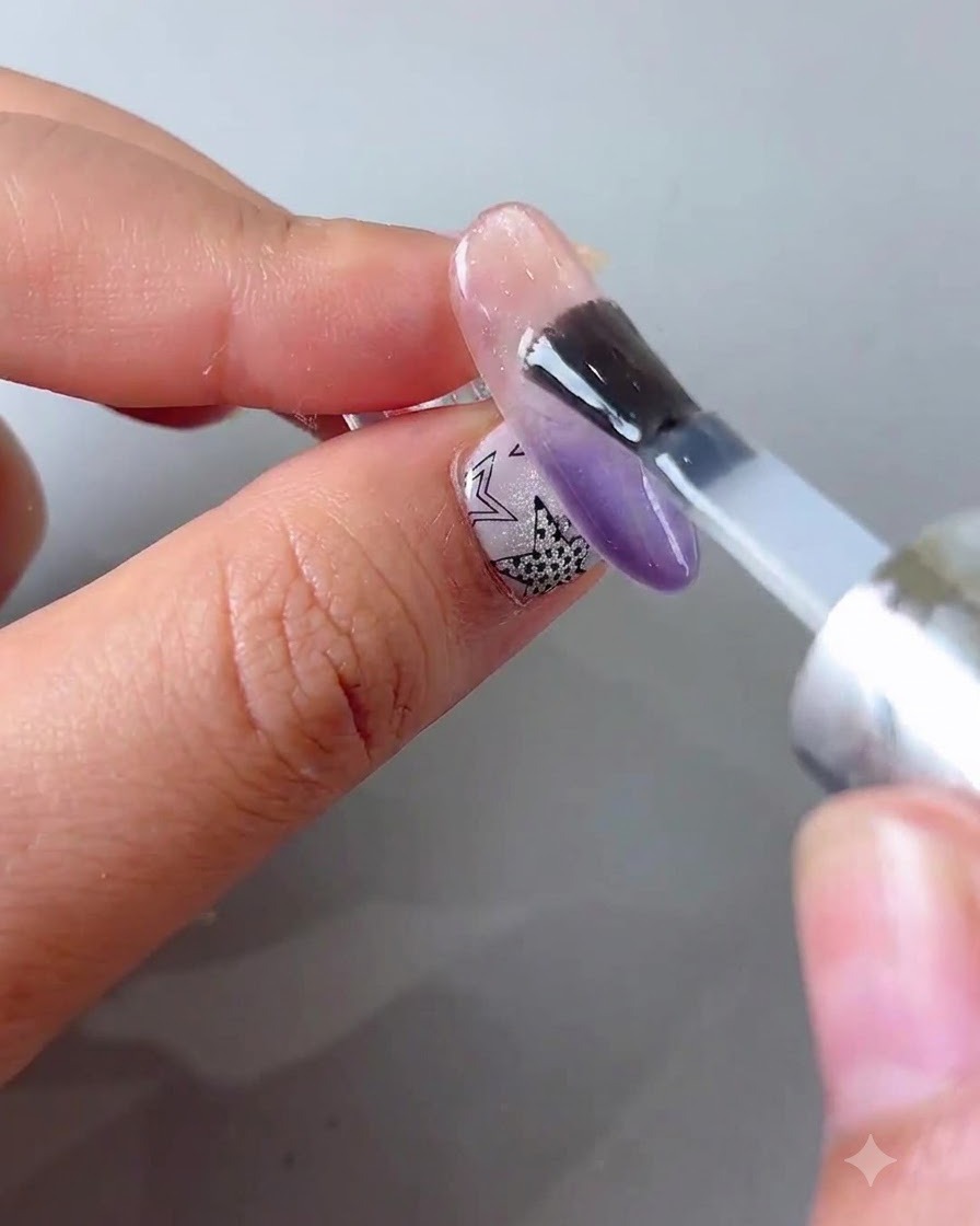 Ein Pinsel, der eine gleichmäßige Schicht klaren Barriere-Gels auf die gesamte vorbereitete Nageloberfläche aufträgt.
