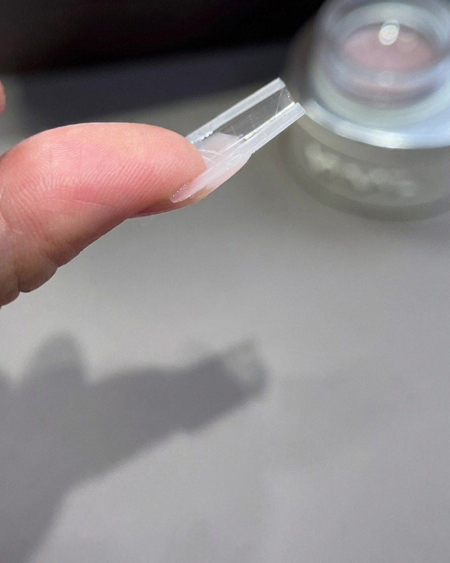 Eine umgekehrte Ansicht einer Nagelverlängerungsschablone zeigt das Profil und die Bogenstruktur des Gels.