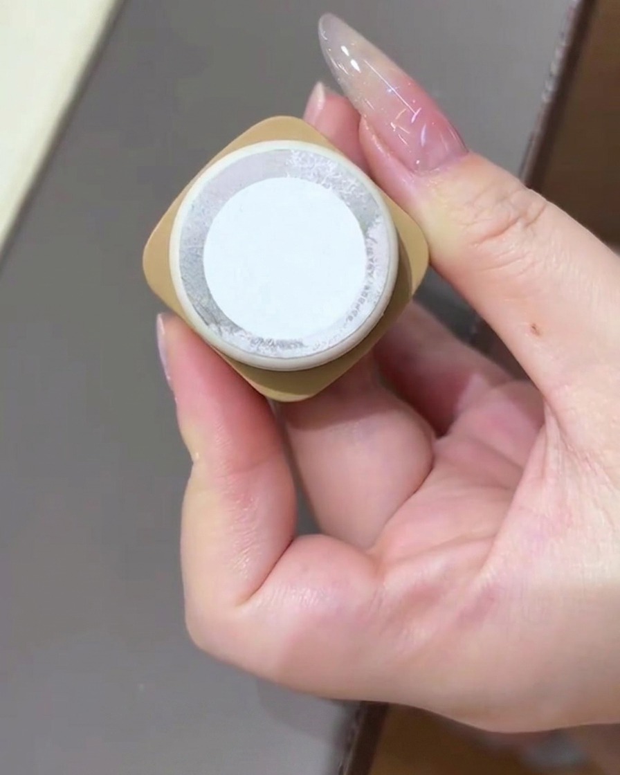 Eine Hand hält eine Flasche Cat-Eye-Gel-Lack in die Kamera.