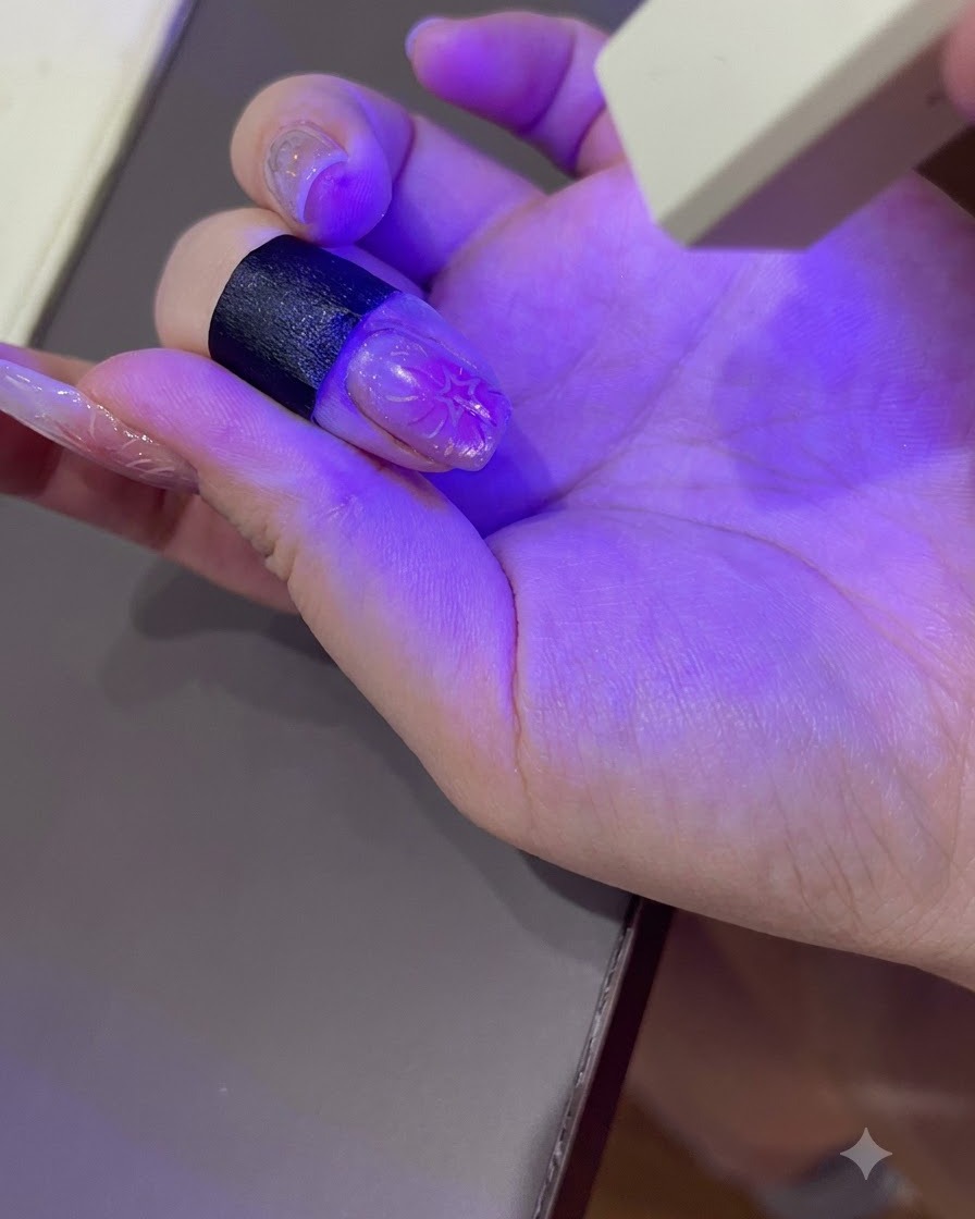 Eine manikürte Hand härtet unter dem violetten Licht einer tragbaren UV-/LED-Nagellampe aus.