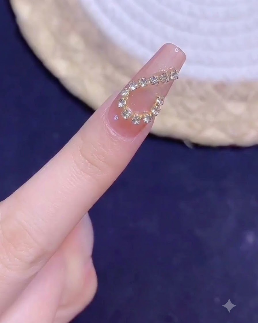 Ein manikürter Finger mit einem goldenen Ketten-Herz-Design im Nahbereich unter Beleuchtung nach dem Aushärten.