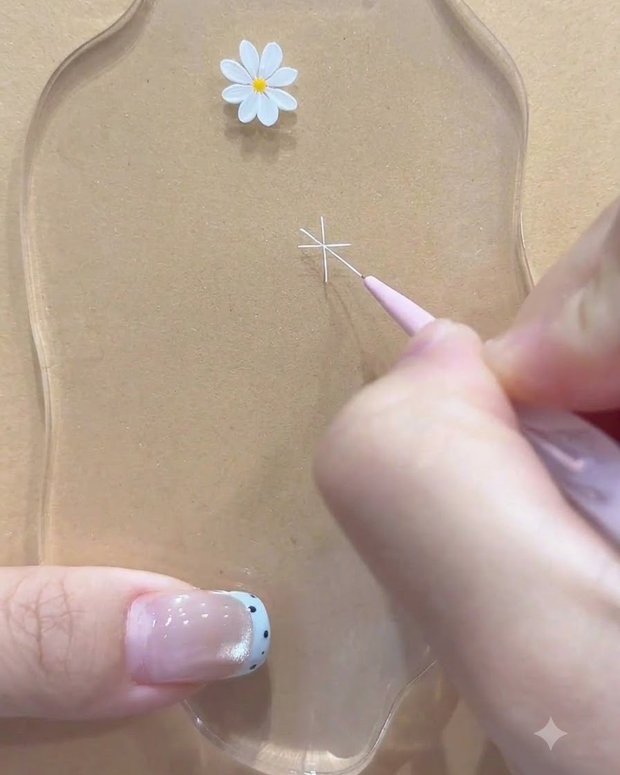 Ein Fine-Liner-Pinsel fügt zusätzliche diagonale weiße Linien hinzu, um die Umrisse der Gänseblümchenblüte zu vervollständigen.