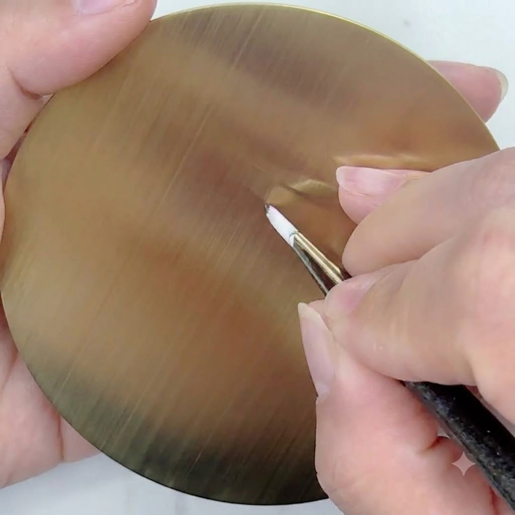 Ein feiner Linerpinsel mit weißem Gel zeichnet gerade, dünne Hilfslinien, die von einem zentralen Punkt auf einer goldenen kreisförmigen Übungspalette ausgehen.