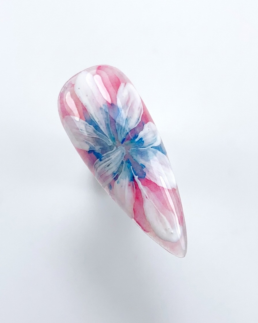 Eine Hand platziert einen dekorierten Nagel unter einer rosa UV/LED-Aushärtungslampe.