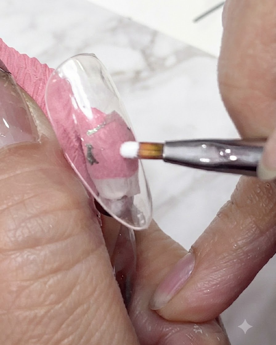 Eine Nahaufnahme eines feinen Liner-Pinsels, der weißes Gel aufträgt, um die ersten Blütenblätter eines Gänseblümchens auf einem klaren Nagel-Tip zu formen.