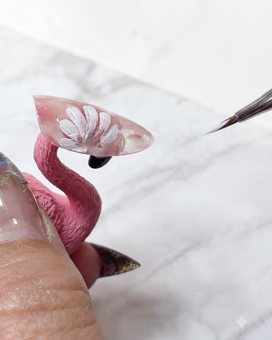 Ein feiner Nail-Art-Pinsel, der die scharfen weißen Spitzen geschichteter Gänseblümchenblätter auf einer transluzenten rosafarbenen Verlängerung ausbessert.