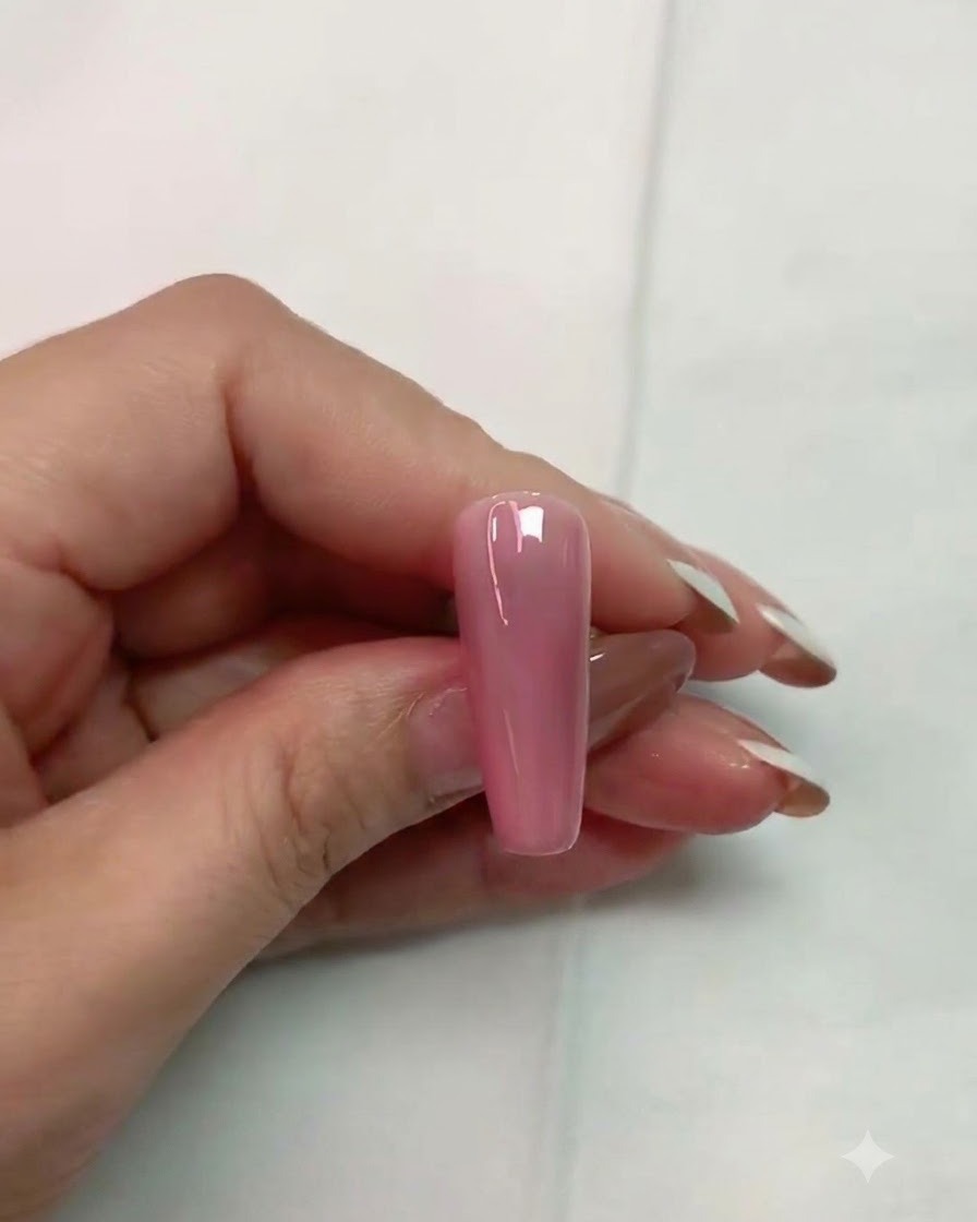 Ein Pinsel trägt klaren matten Topcoat auf eine glänzende pinke Kunstnageloberfläche auf.