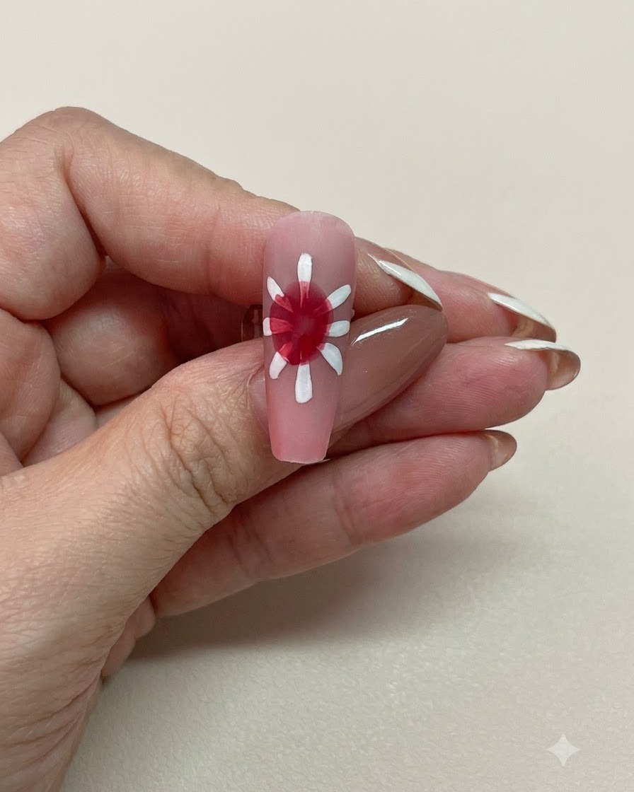 Nahaufnahme eines pinken Nagels mit sanft verlaufendem roten Blooming-Zentrum umgeben von weißen Blütenblättern.