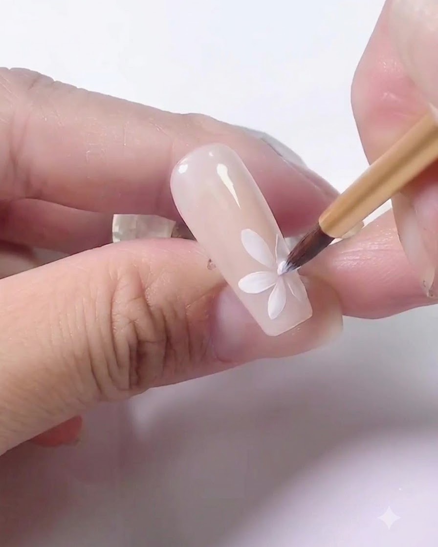 Eine Hand, die einen Übungsnagel zum Aushärten unter eine UV-Lampe legt.