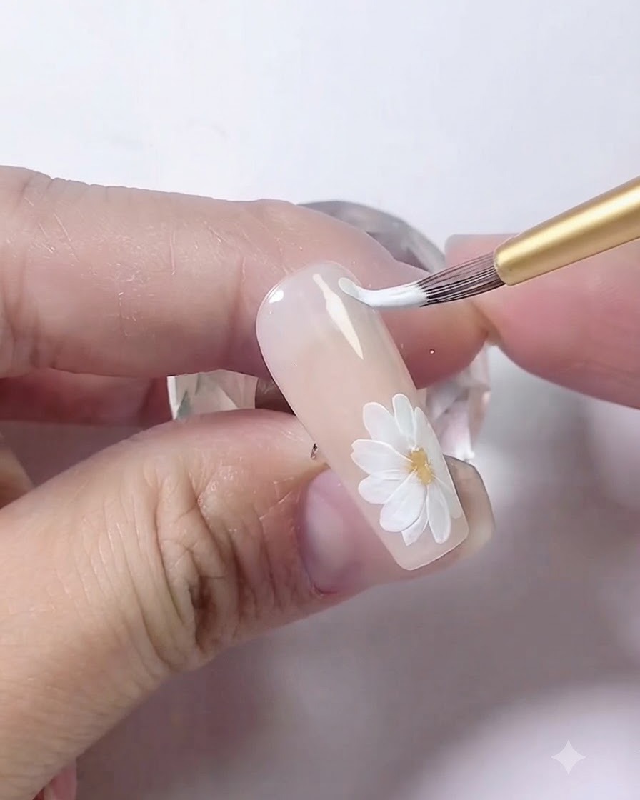 Ein Nail-Art-Pinsel, der zwei parallele, geschwungene weiße Linien entlang der Nagel-Seitenkante zeichnet.