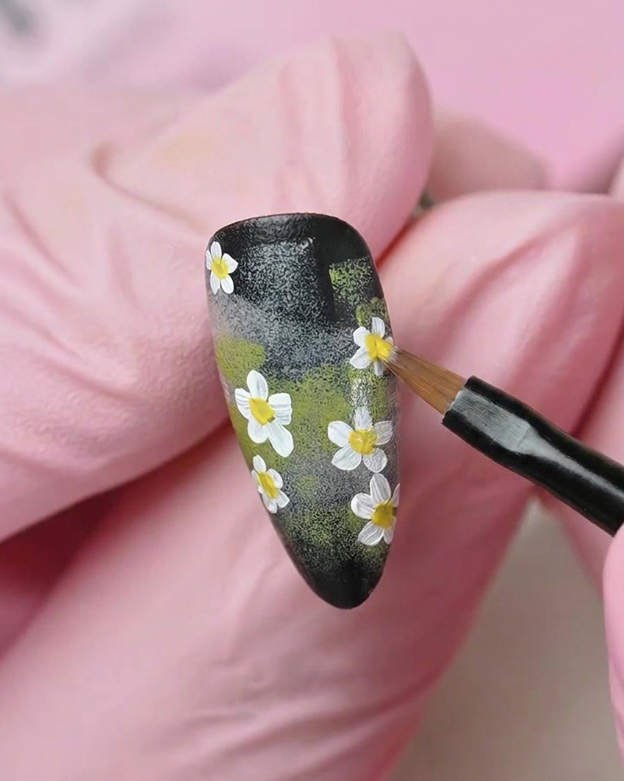 Ein flacher Pinsel glättet eine Schicht aus durchscheinendem, milchig-weißem Gel-Nagellack über die Nageloberfläche.