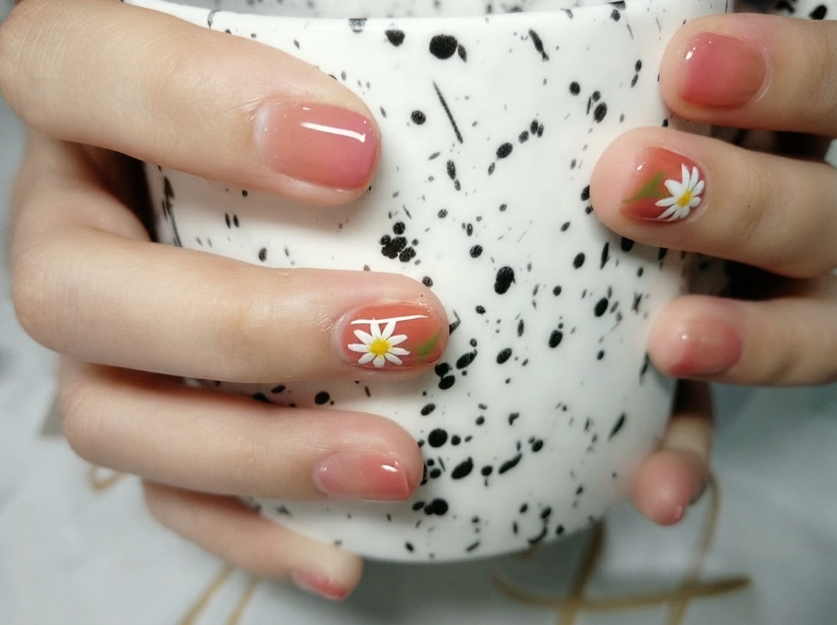 Makroaufnahme eines detaillierten weißen Gänseblümchen-Nagelkunst-Designs auf warmem Hintergrund mit heller Beleuchtung.