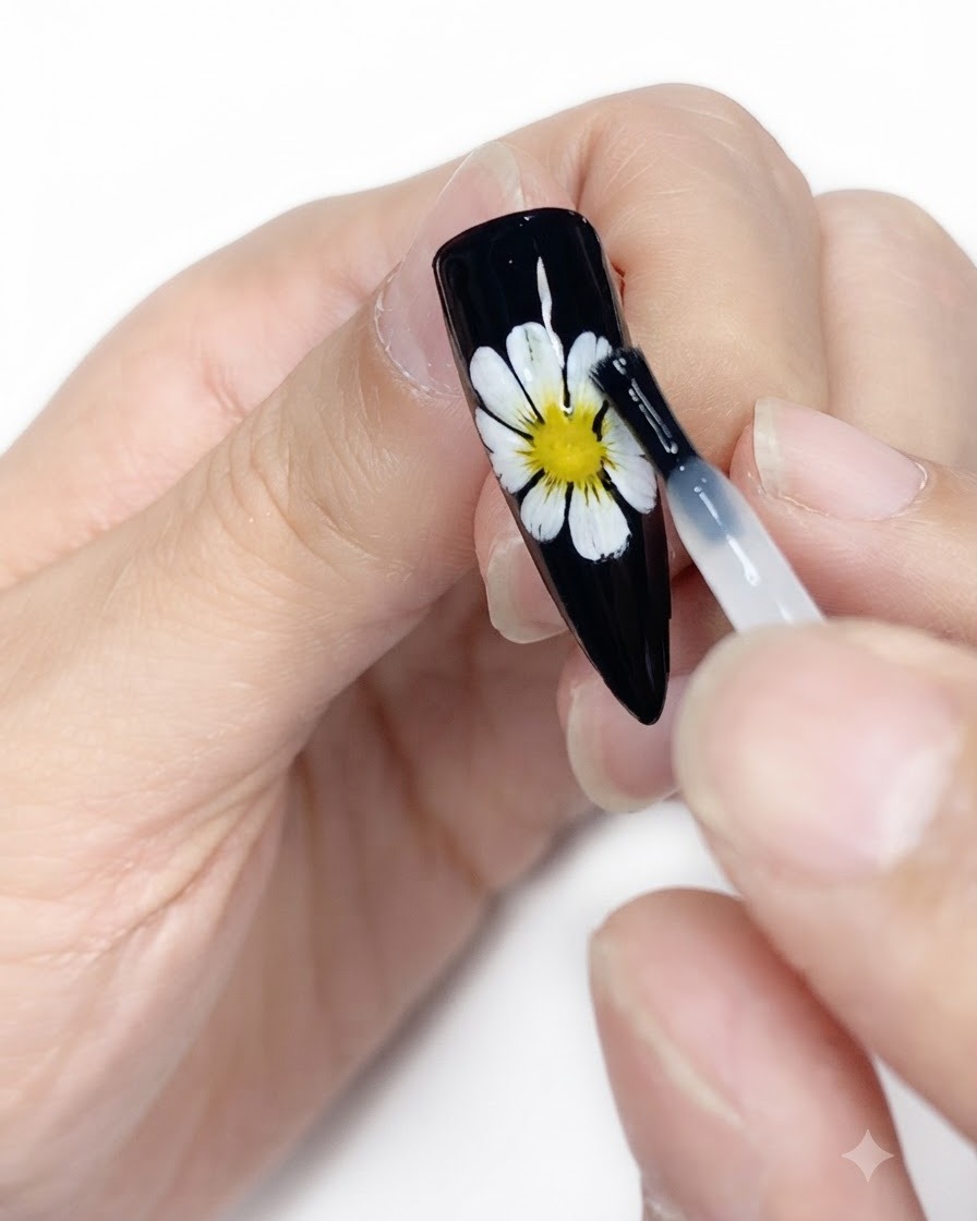 Ein Reinigungstuch säubert die Oberfläche eines fertigen schwarzen Nagels mit weiß-gelbem Gänseblümchen-Design.