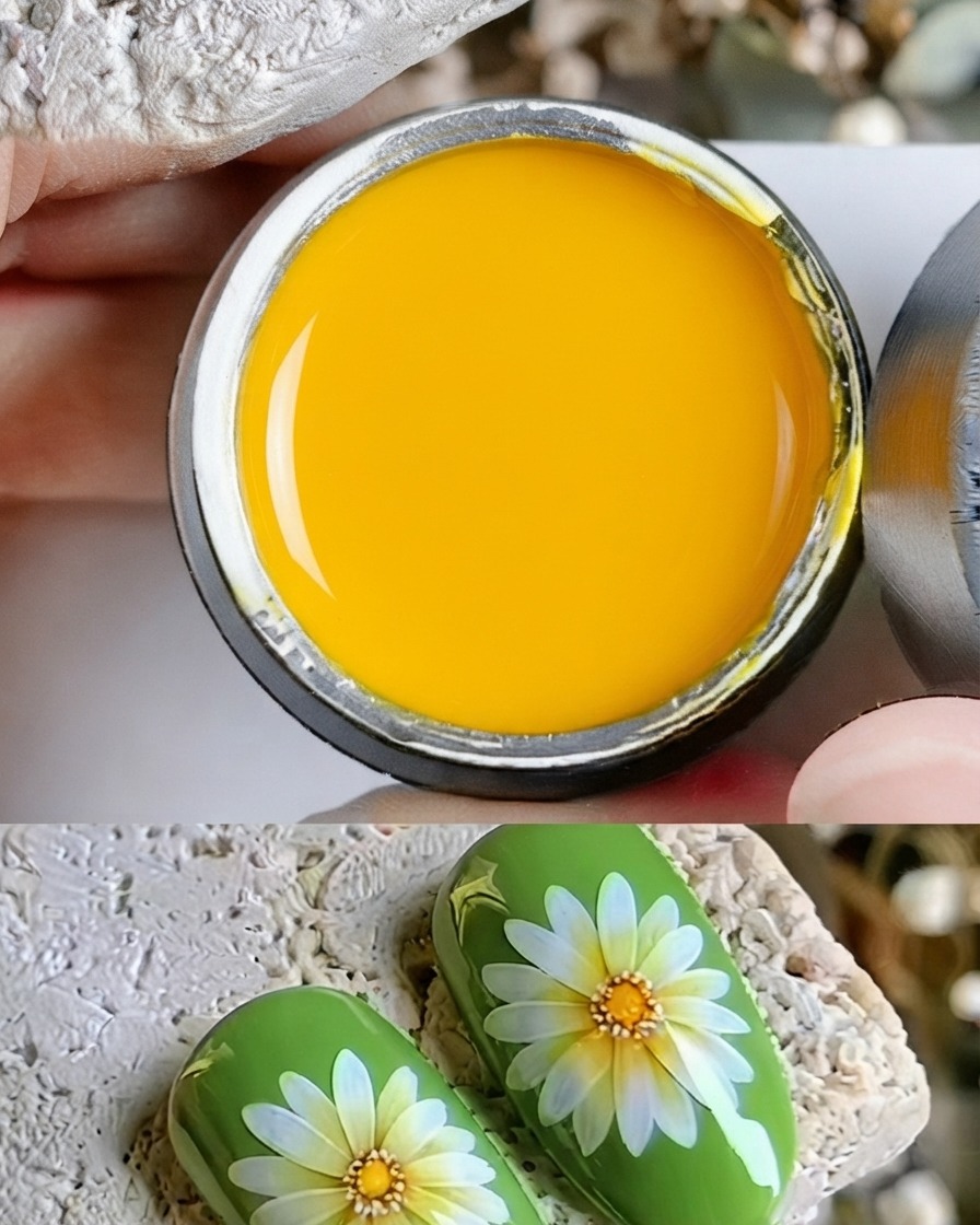 Nahaufnahme eines feinen Pinsels, der einen Tropfen gelbes Gel auf die Mitte eines gemalten Gänseblümchens aufträgt.