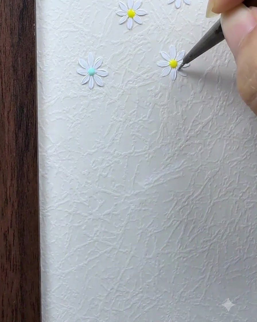 Ein feiner Pinsel füllt die restlichen weißen Blütenblätter um das Zentrum der Gänseblümchen-Blume herum aus.