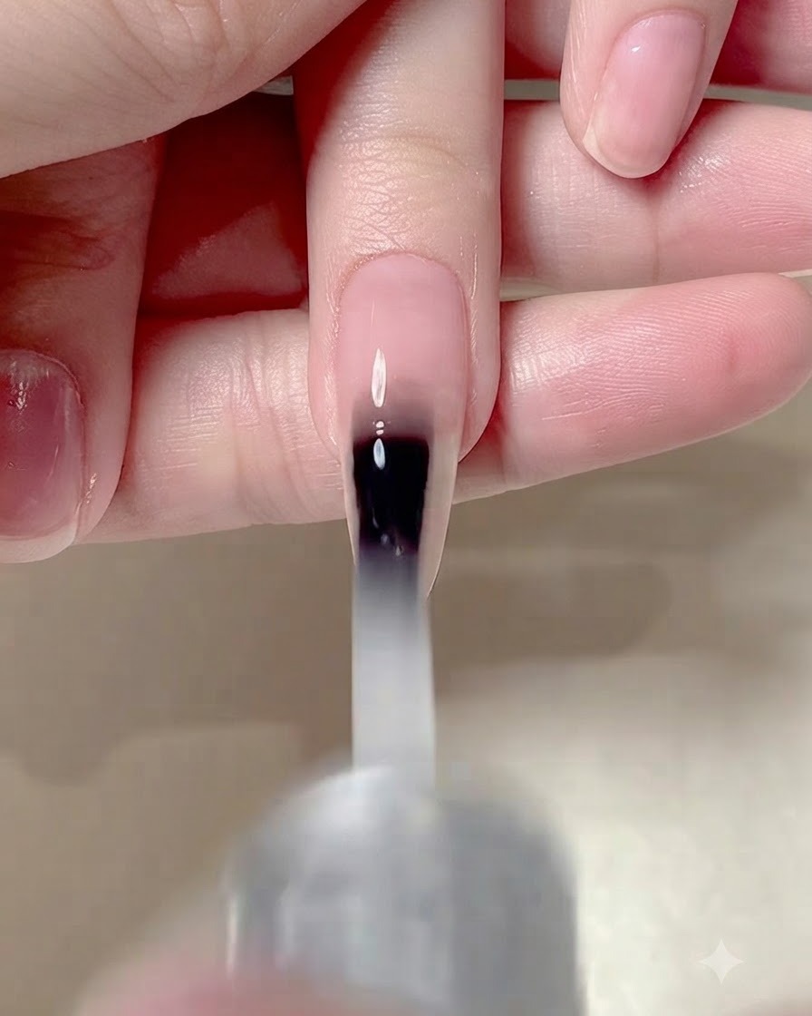 Ein Nagelpinsel trägt einen matten Überzug auf die gesamte Oberfläche eines manikierten Nagels auf.