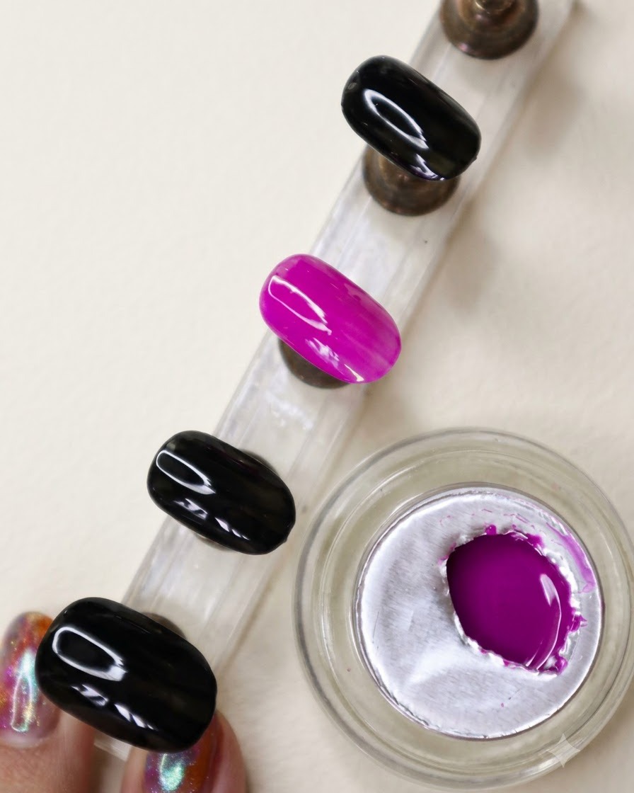 Ein Präsentationsständer zeigt einen Akzentnagel mit einem vollständig deckenden, leuchtend neonvioletten Finish.