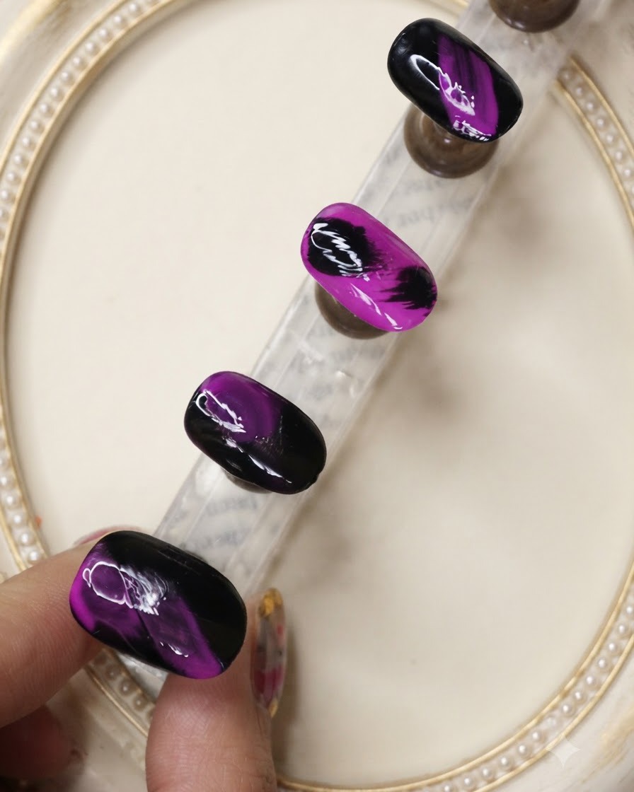 Ein Überlack-Pinsel trägt eine schützende Schicht über die strukturierten schwarzen und neonvioletten Nageldesigns auf.