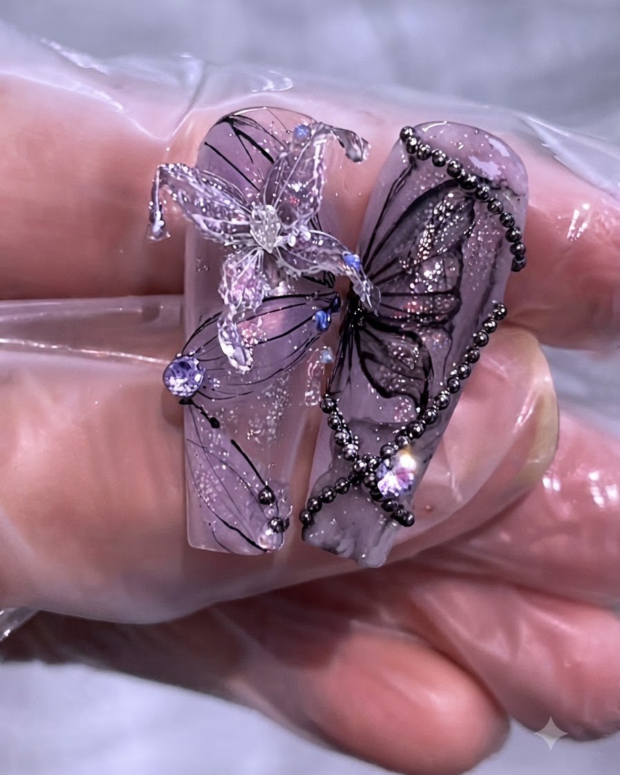 Nahaufnahme eines fertigen Sets von lila Schmetterlings- und Ketten-Nageldesigns auf langen, klaren Nagelspitzen.