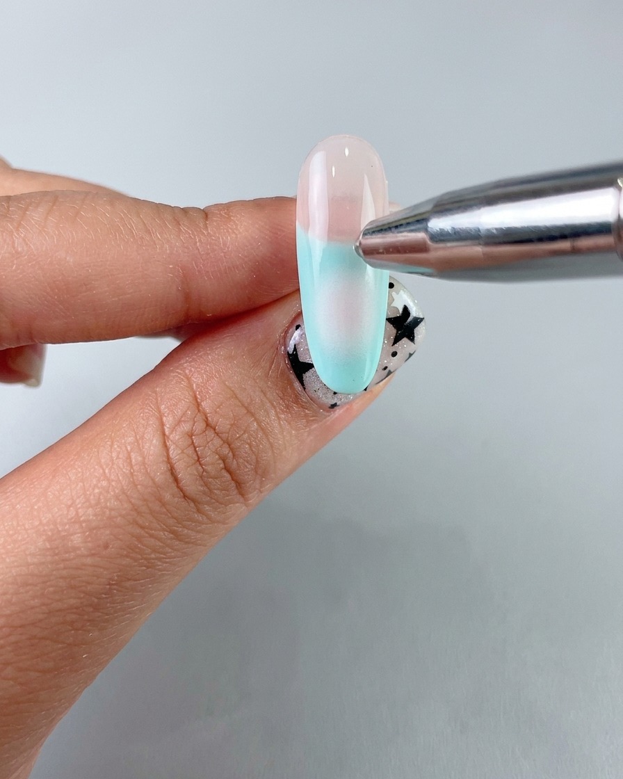Ein Schwämmchen-Applikator trägt mit sanftem Gel ein weiches Blush-Zentrum auf den Nagel auf.