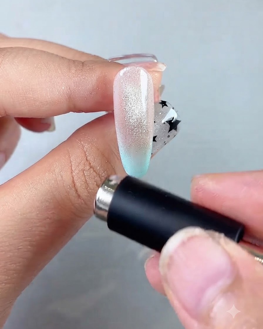 Ein Magnetstab kreist um den Nagelrand, um ein konzentriertes, leuchtendes Glaskugelzentrum zu formen.