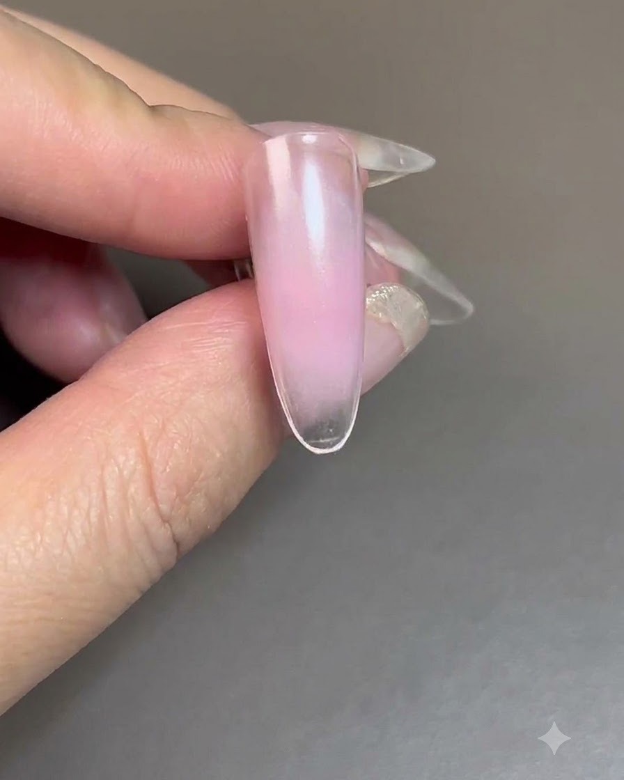 Ein Nagel mit aufgetragenem Blush-Gel, der unter einer UV/LED-Nagellampe aushärtet.