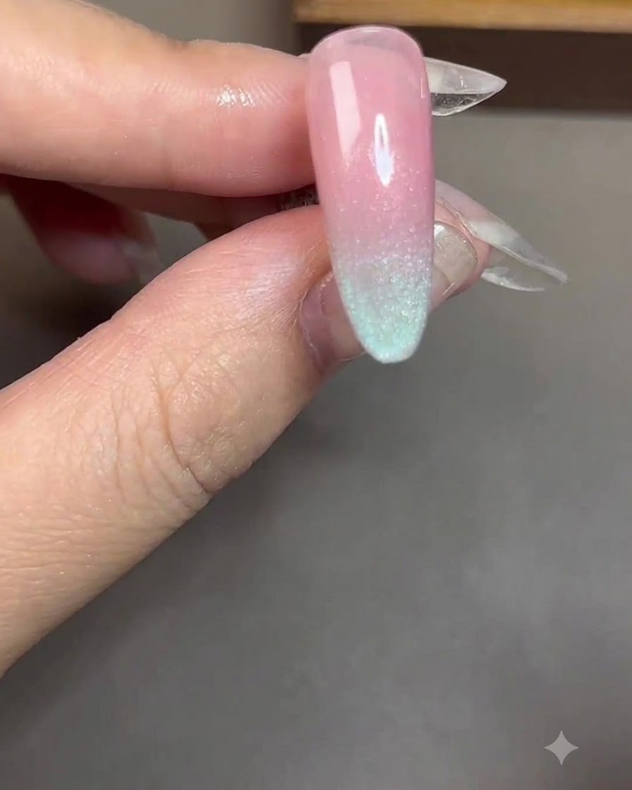 Ein zylindrischer Magnet wird nah und parallel über einen Nagel mit blauem Cat-Eye-Gel gehalten.