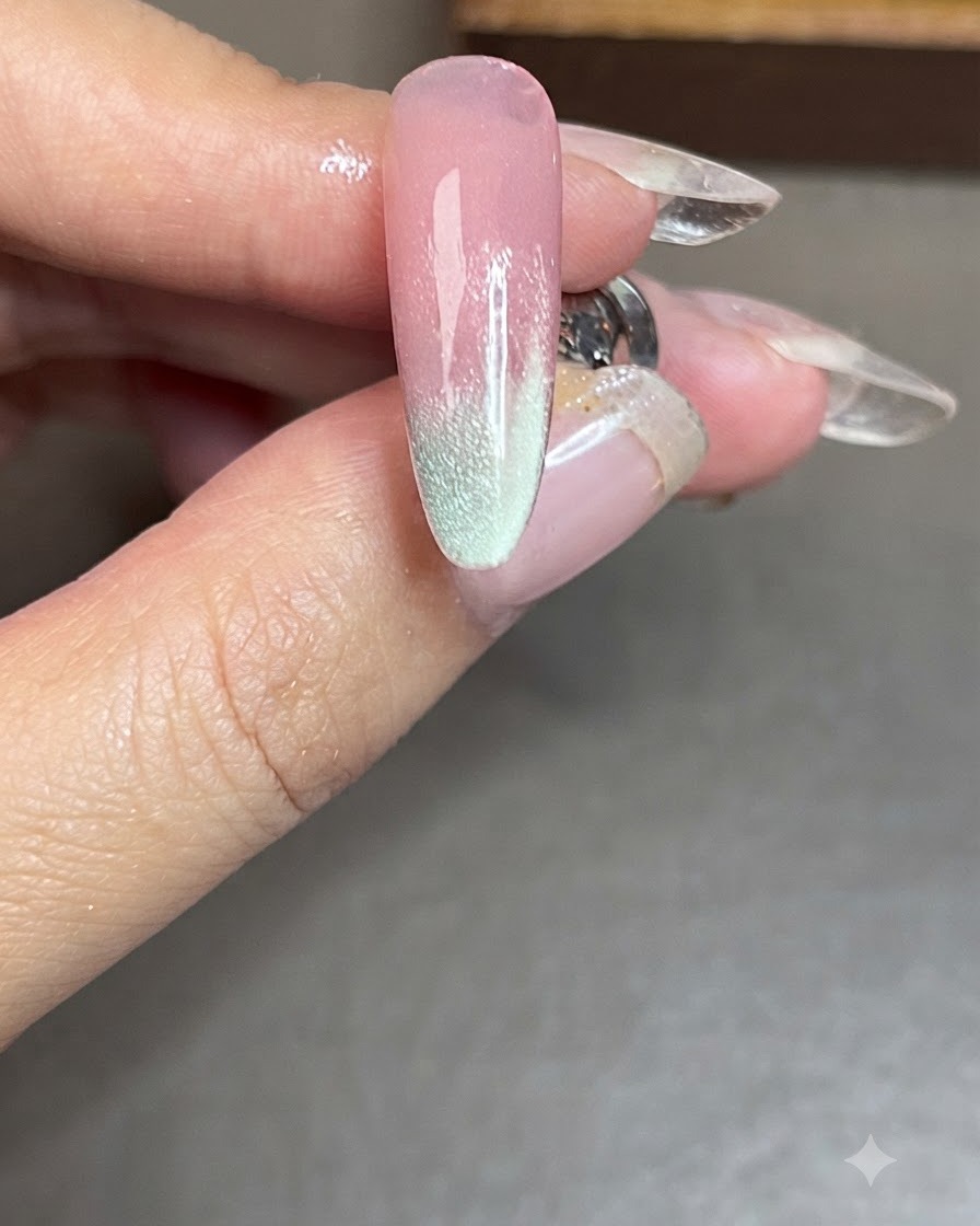 Ein Nagel mit einem fertigen blauen Cat-Eye-Streifen an der Seite, der unter einer Lampe ausgehärtet wird.