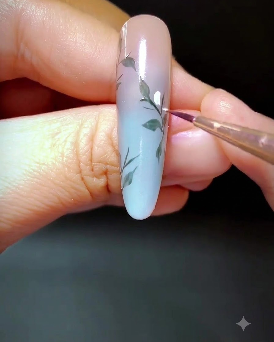Eine Nahaufnahme eines verzierten Nagels, auf dem weiße Gelpunkte entlang des gemalten Zweigs aufgetragen werden.
