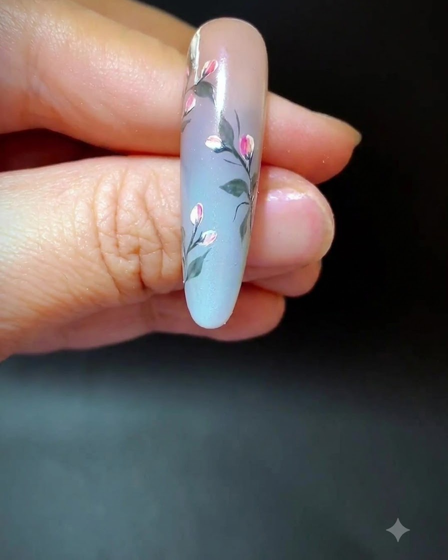 Ein Nagel mit fertiger floraler Kunst und zusätzlichen langen, zarten Akzentlinien über der Ombré-Fläche.
