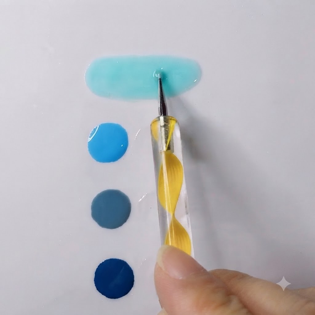 Ein Dotting-Tool verblendet ein leuchtend himmelblaues Gel mit transparentem Gel zu einer glatten, länglichen Pfütze.