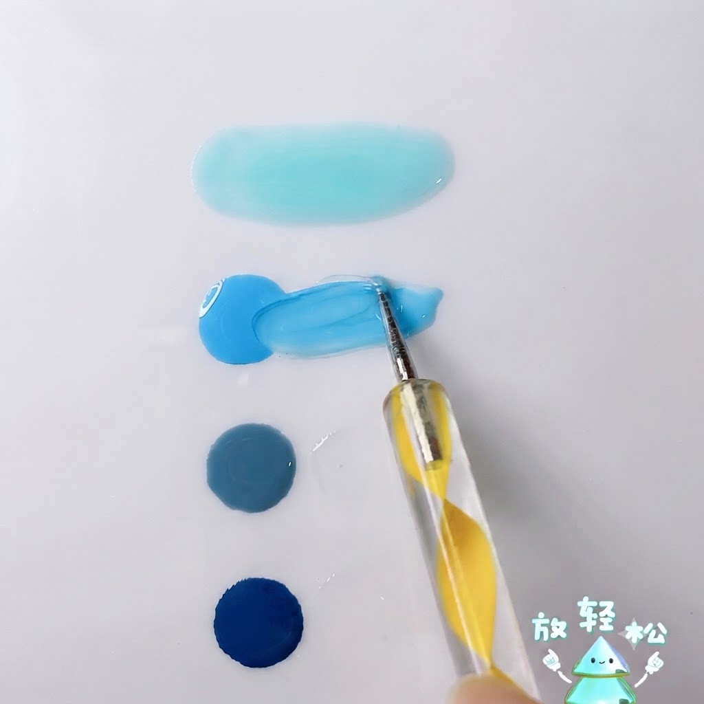 Ein Dotting-Tool mischt leuchtend himmelblaues Gel mit transparentem Gel auf einer weißen Palettenoberfläche.