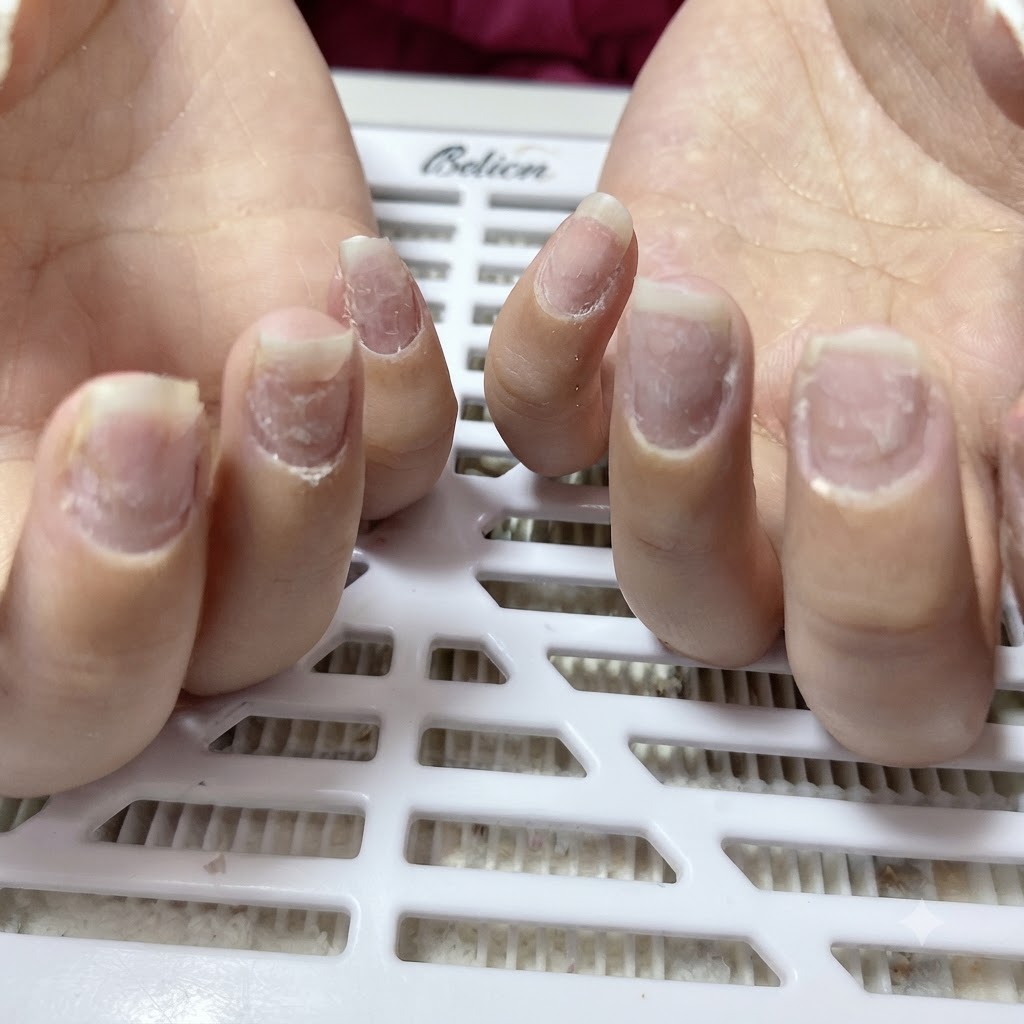 Nahaufnahme von Naturnägeln in Mandelform mit Nagelstaub an der Nagelhaut.
