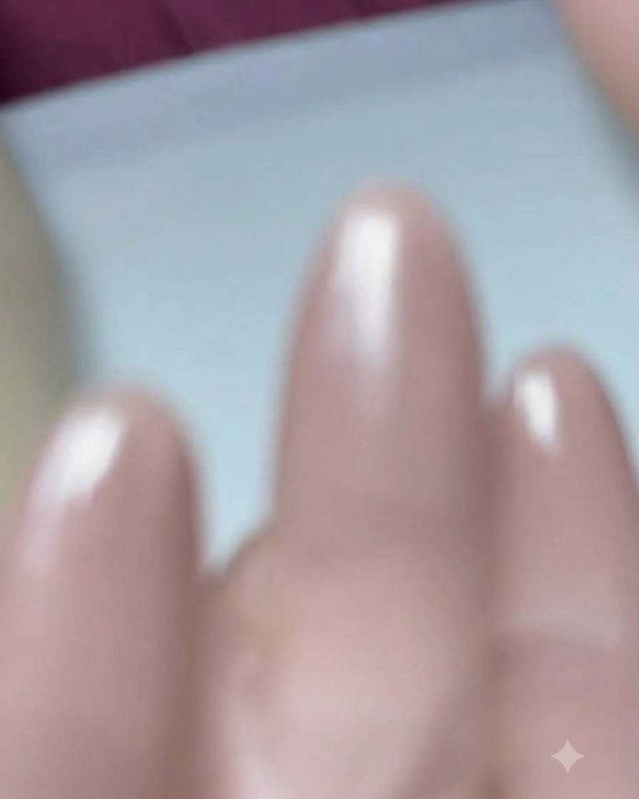 Ein Pinsel trägt Base Coat Gel auf einen vorbereiteten Mandel-Nagel auf.