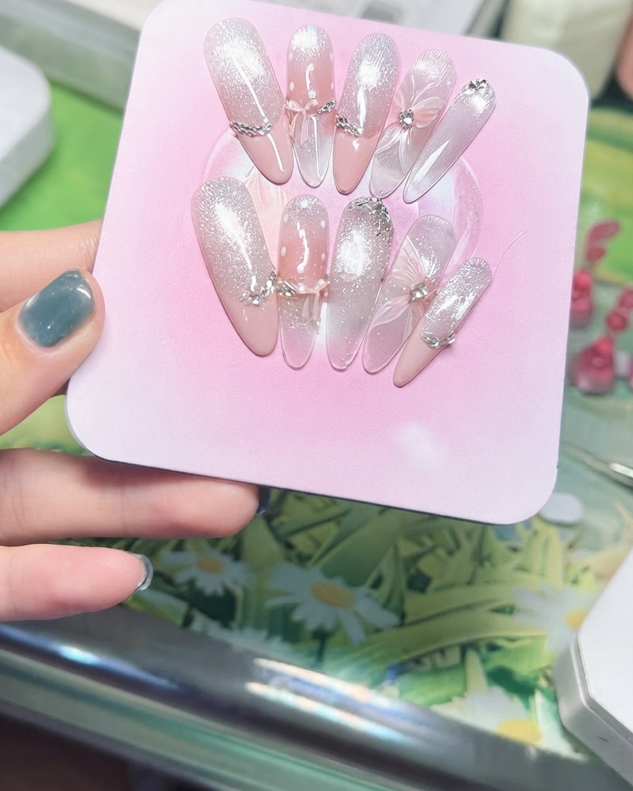 Eine Hand neigt ein rosa Präsentationsboard, um die funkelnden, magnetischen Cat-Eye-Partikel im Lichteinfall zu zeigen.