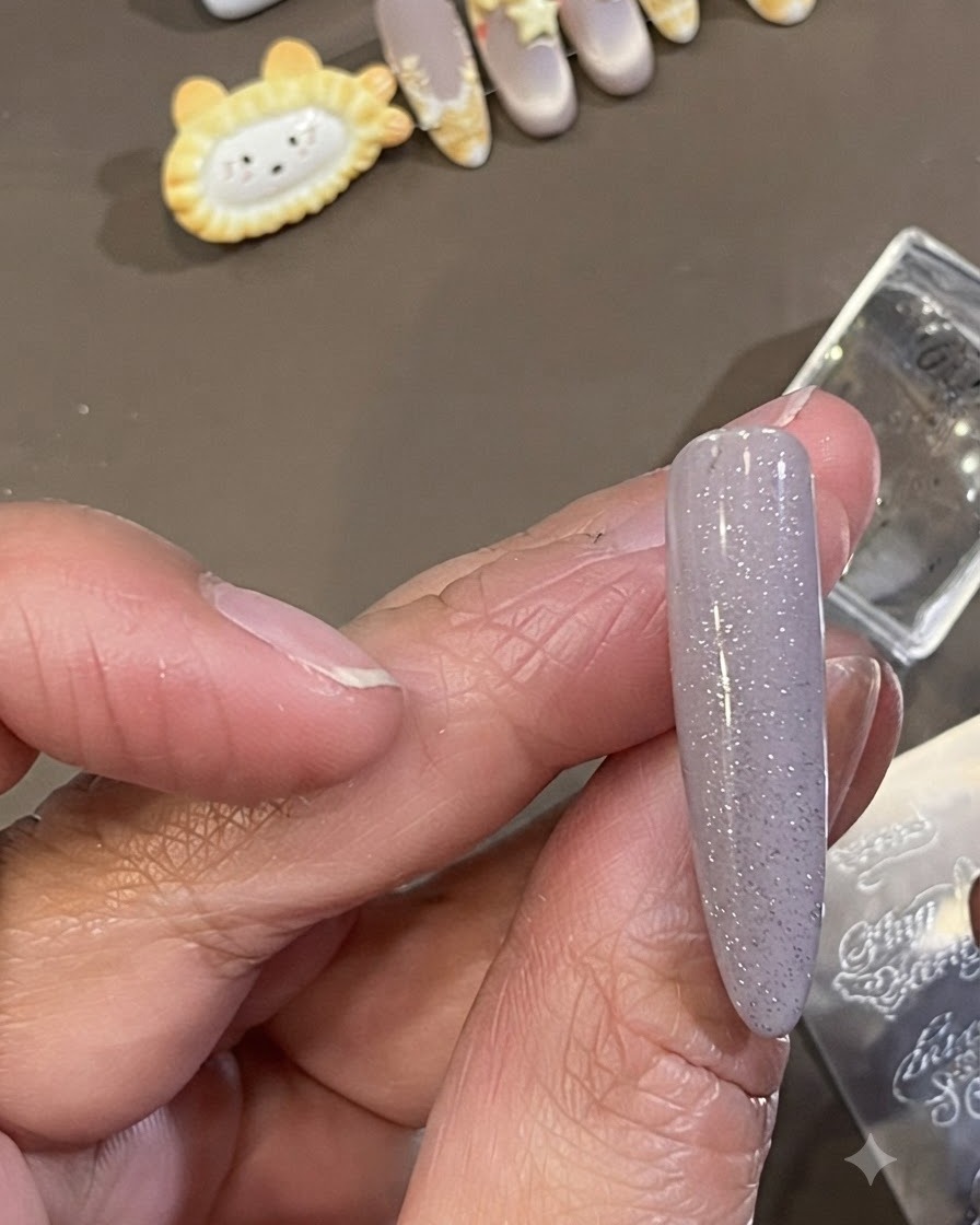Ein kleiner Reinigungspinsel wischt überschüssigen dunklen Stamping-Lack von der Haut um die Seite eines manikürten Nagels weg.