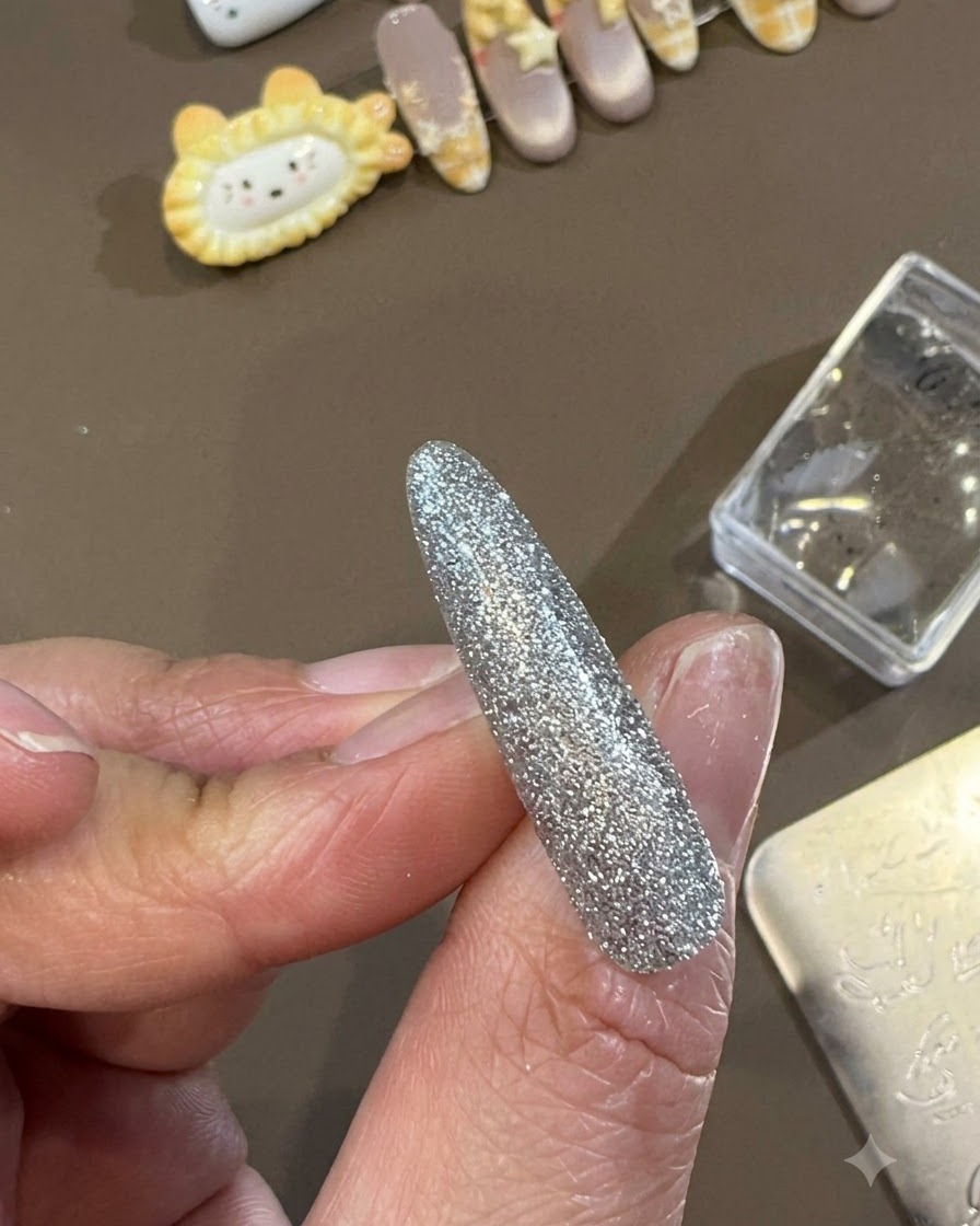 Ein Gel-Top-Coat-Pinsel gleitet in einer glatten, glänzenden Top-Coat-Schicht über ein fertiges dekoratives Nageldesign.