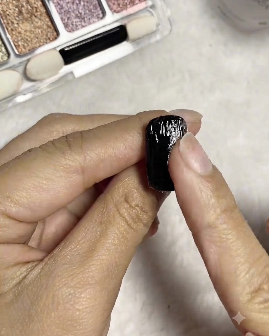 Ein Finger reibt silbernes Spiegelpuder direkt in die feuchten, strukturierten Linien des Nagels ein.