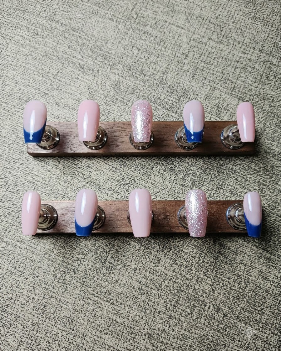 Ein Pinsel trägt silbernes Crushed Diamond Gel entlang der Smile-Linie eines French Nails auf.