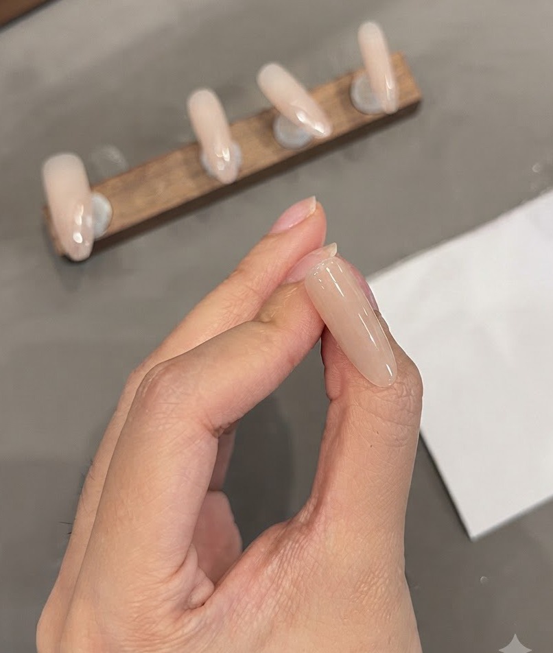 Nahaufnahme eines Mandel-Nangels mit präzisen weißen Feinlinien nahe dem Nagelbett.